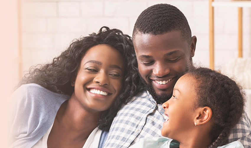Smiling african american family relaxing on couch and watching TV at home, man switching channels