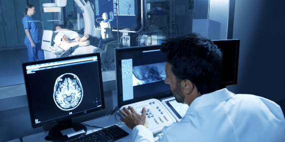 Doctor looking at scan while patient is in testing room