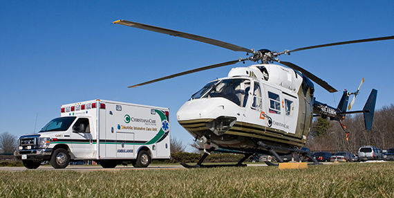 A ChristianaCare ambulance and helicopter parked next to each other.