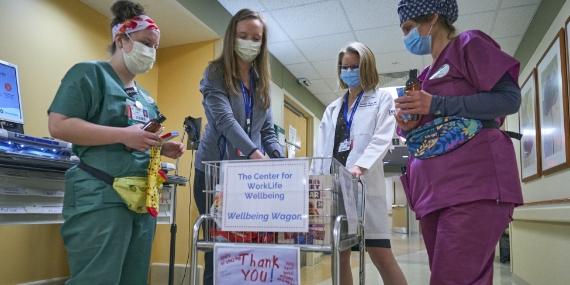 Doctors roll the Center for WorkLife Wellbeing's wagon through hospital units