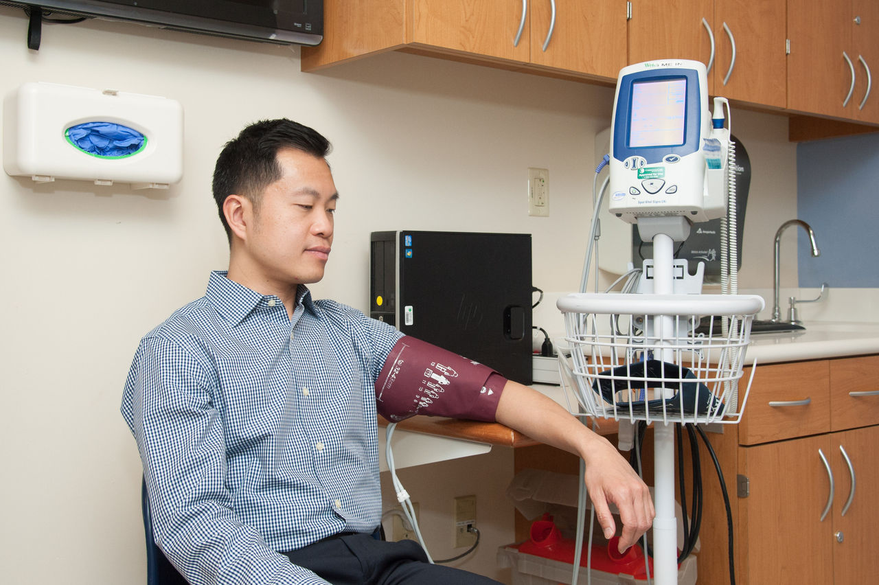 Man undergoing blood pressure measurement in clinic Man undergoing blood pressure measurement in clinic