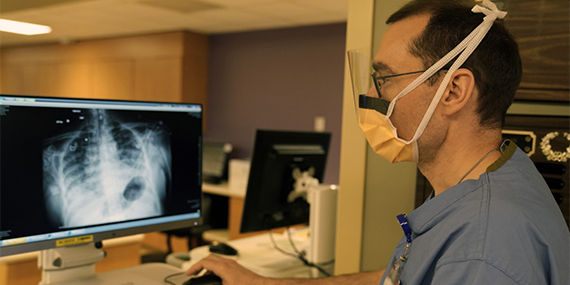 A medical provider reads a chest x-ray on a computer screen