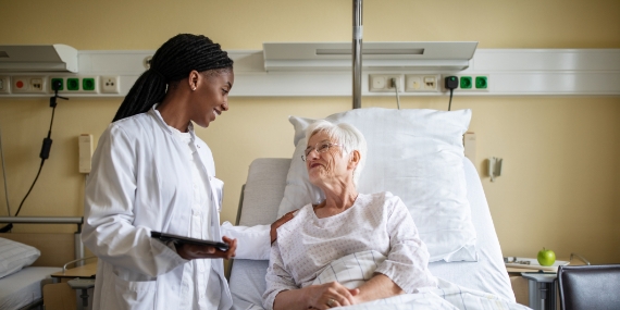 Doctor consoling senior patient during visit